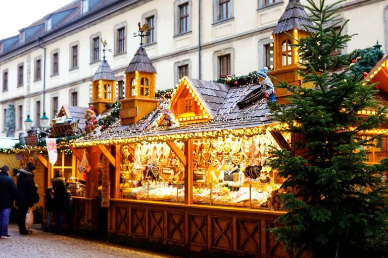 Traditioneller Weihnachtsmarkt im historischen Zentrum von Nürnberg, Deutschland. Geschmückt mit Girlanden und Lichtern Verkaufsstände mit Süßigkeiten, Glühwein und Weihnachtsdekoration und deutschen Geschenken.
