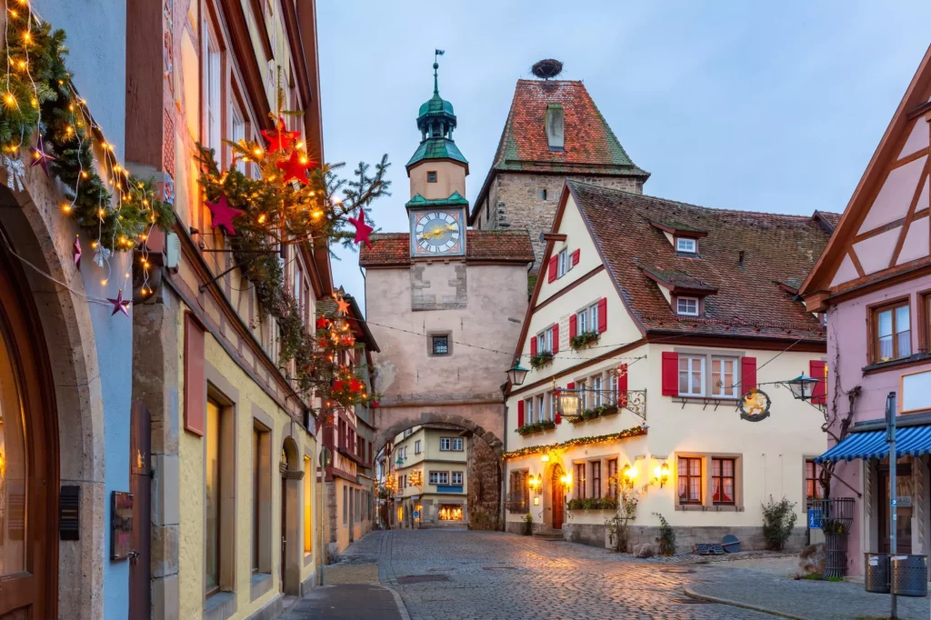 Decorated and illuminated Christmas street with gate and tower Markusturm in medieval Old Town of Rothenburg ob der Tauber, Bavaria, southern Germany