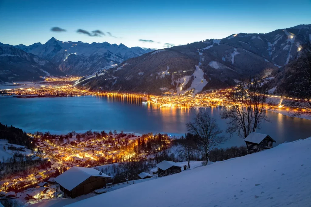View over Zell am See mountain village at night in winter, Salzb